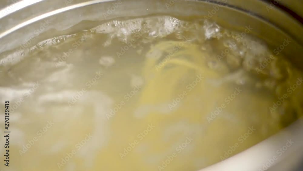 Zoom in - Close-up of boiling hot water for spaghetti italian food inside silver metal hot pot Zoom in - Close-up of boiling hot water for spaghetti italian food inside silver metal hot pot