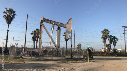 Oil drilling rig in Newport, California, USA. Cars driving in the background.