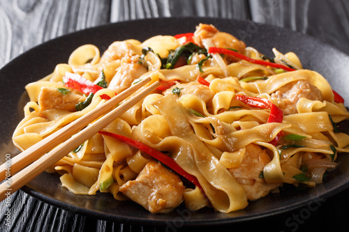 Tableau sur toile Pad Kee Mao is a traditional Thai dish with chicken, wide rice noodles and plenty of fresh basil in a spicy, sweet and tangy rich sauce  close-up