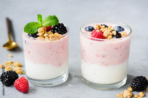 Blueberry yogurt parfait with granola, berries in glass on gray concrete background. Concept of weight loss, healthy eating, healthy dessert food