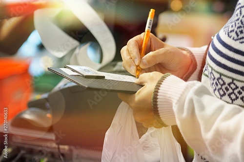 People shopping and sign on paper bill closeup
