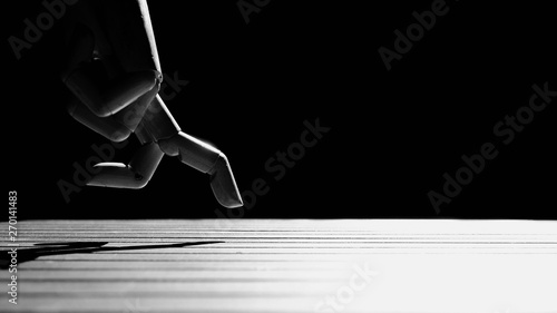 Close up wood mannequin's hand in running gesture with sunlight and shadow on plank floor surface in dark background, black and white style, create idea of run for health or step to goal concept