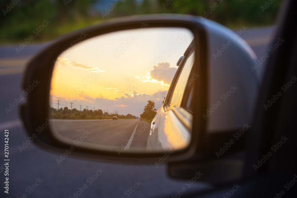 mirror to see perspective road behind on sunset time.
