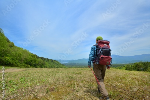 高原のトレッキング・草原を歩く男性