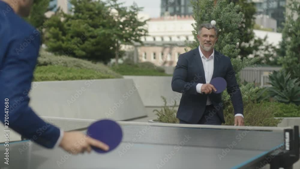 Two business partners have fun leisure time together playing table tennis outside of office. Two business partners have fun leisure time together playing table tennis outside of office.