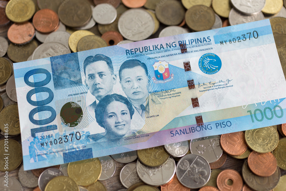 A pile of new and old Philippine peso coins with one thousand