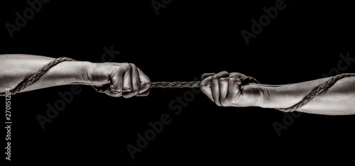 Hand holding a rope, climbing rope, strength and determination. Rescue, help, helping gesture or hands. Conflict, tug of war. Two hands, helping hand, arm, friendship. Rope, cord. photo