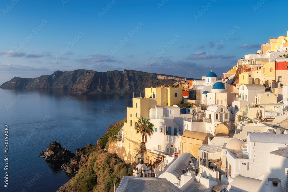 Obraz premium Sunrise at blue domed churches on Santorini Greek Island, Oia town, Santorini, Greece.