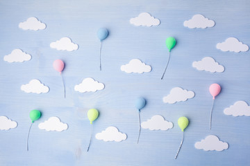 Baby background with balloons and white clouds on blue wooden background