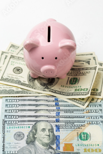 Pig piggy bank on the background of 100 US dollar bills and physical coins of bitcoins. Concept of wealth and exchange. 