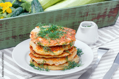 Delicious pancakes from courgettes and fresh vegetables with sour cream and dill