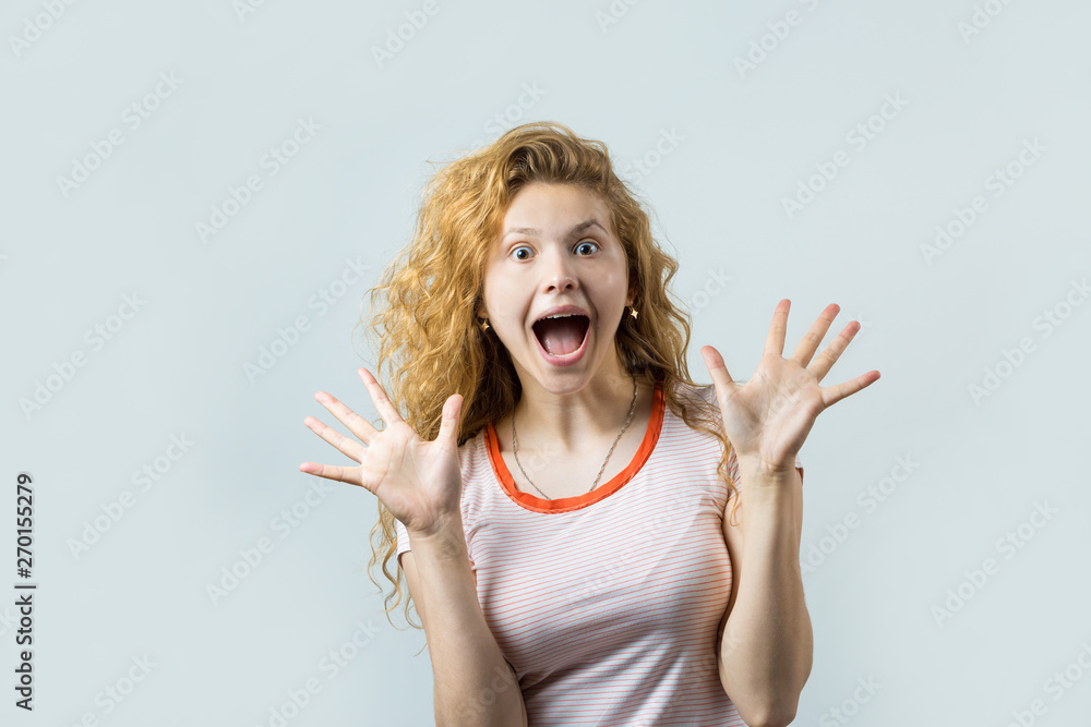 Emotional portrait of a red-haired girl on a gray background, stormy emotions, business concept. Emotional portrait of a red-haired girl on a gray background, stormy emotions, business concept.