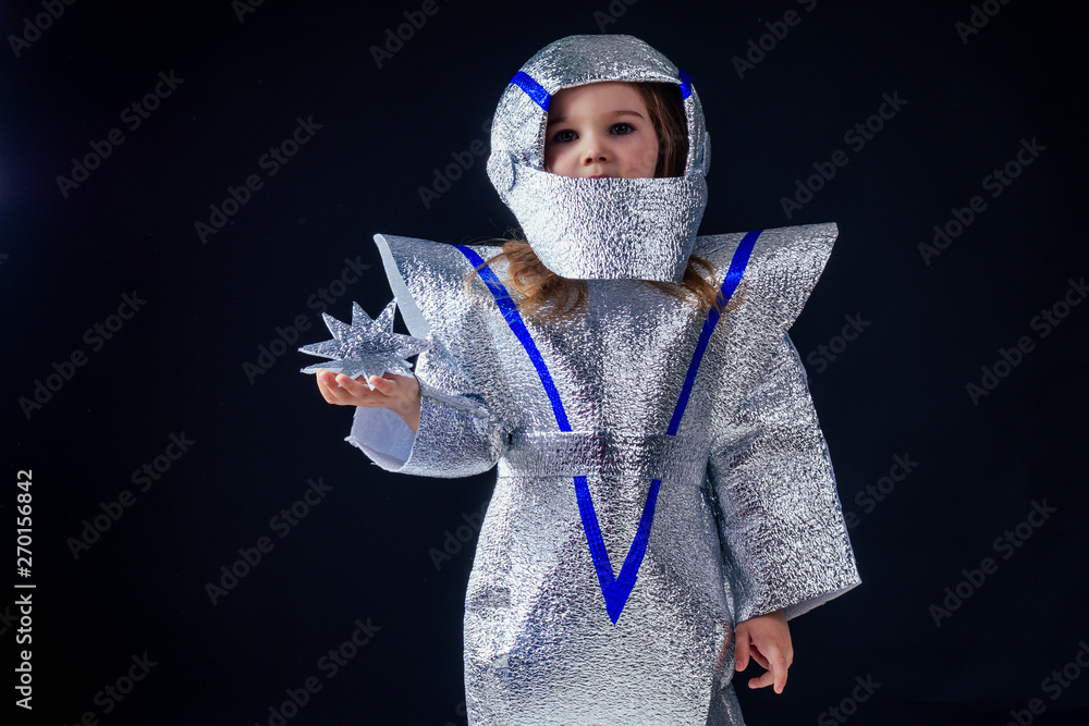 Astronaut girl with silver uniform and helmet studio black background
