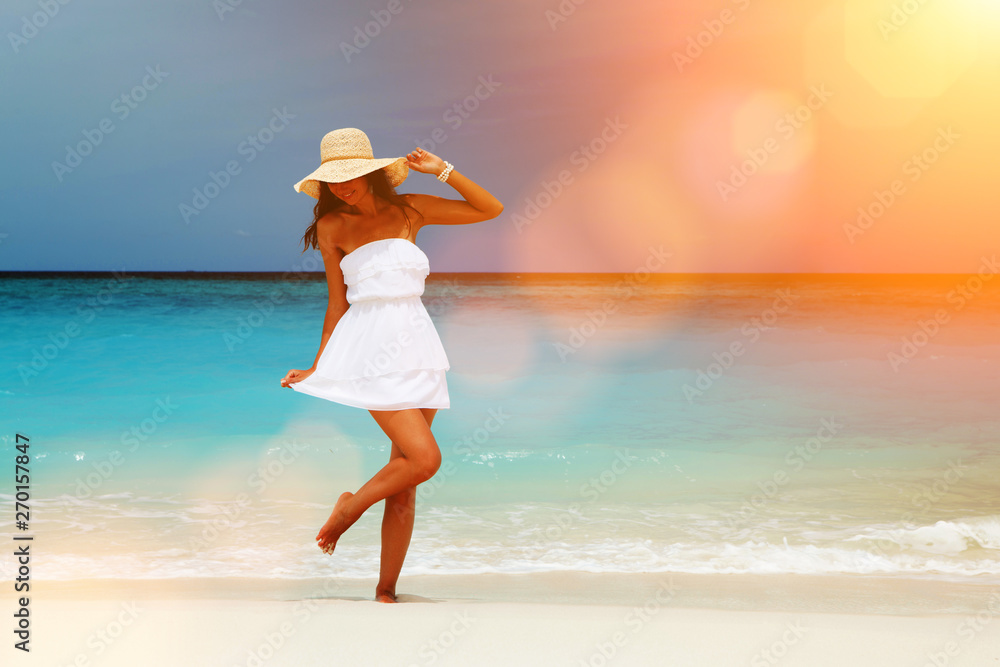 Fashion woman dancing on the beach. Happy island lifestyle. White sand, blue cloudy sky and crystal sea of tropical beach. Vacation at Paradise. Ocean beach relax, travel to Maldives islands