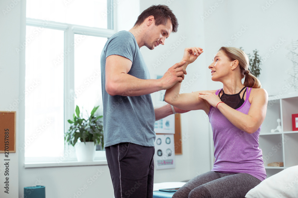 Obraz premium Pleasant good looking woman showing her hand to the doctor