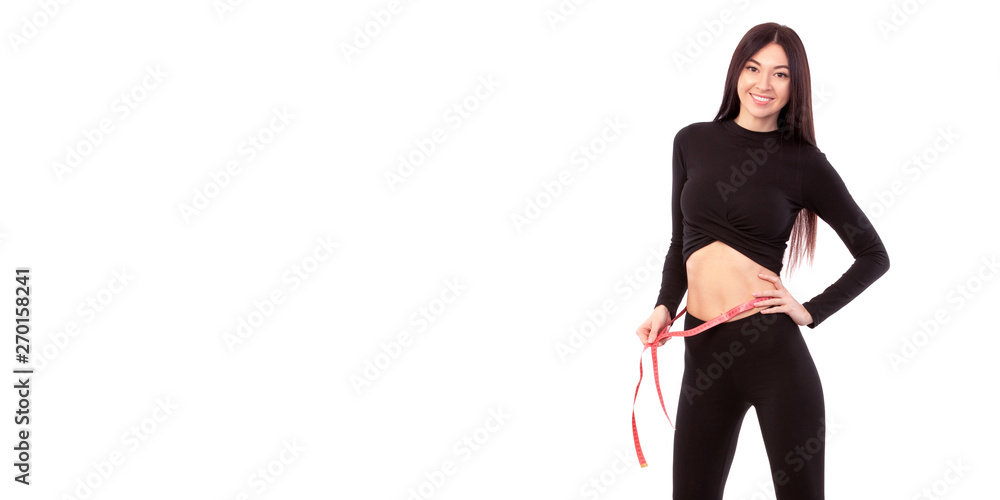 Fototapeta premium Pretty woman in black suit isolated on white background Close up of sporty and beautiful female body. Woman with measure tape. Healthy lifestyle, dieting, fitness, weight loss concept