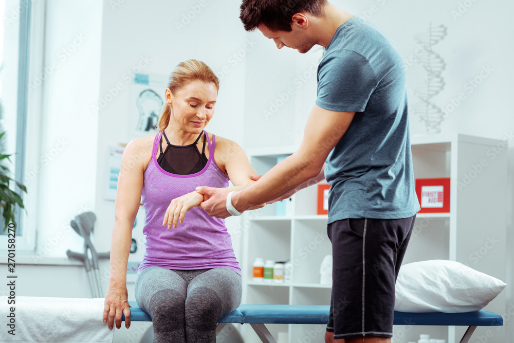 Fototapeta premium Nice positive woman looking at her arm