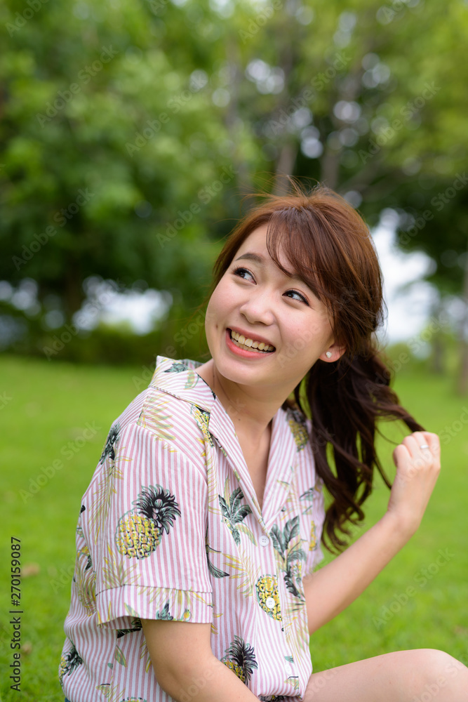 Young beautiful Asian tourist woman relaxing at the park Young beautiful Asian tourist woman relaxing at the park