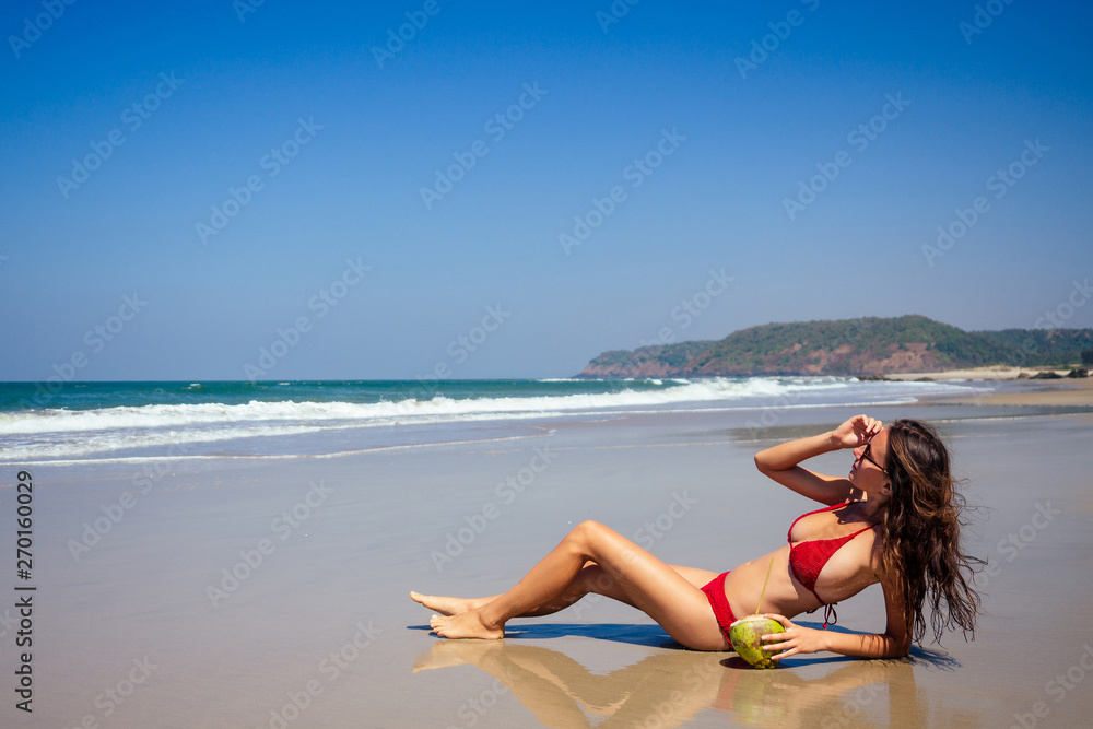 beautiful tanned female fitness big boobs model in a fashion stylish swimsuit on sea ocean beach blue sky and palm trees background.summer vacation beautiful tanned female fitness big boobs model in a fashion stylish swimsuit on sea ocean beach blue sky and palm trees background.summer vacation