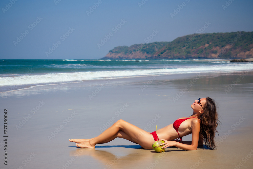 beautiful tanned female fitness big boobs model in a fashion stylish swimsuit on sea ocean beach blue sky and palm trees background.summer vacation beautiful tanned female fitness big boobs model in a fashion stylish swimsuit on sea ocean beach blue sky and palm trees background.summer vacation