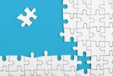 Unfinished white puzzle pieces on blue background