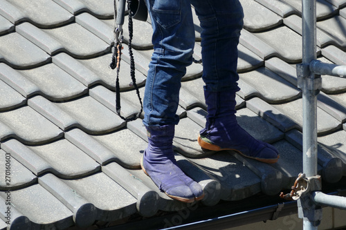地下足袋を履いて屋根の上で作業する男