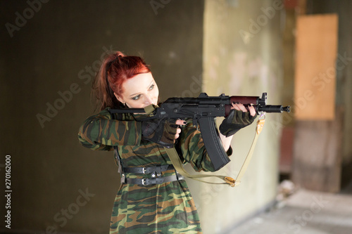 Girl soldier in uniform. The girl in the black beret. Camouflage t-shirt on the girl.