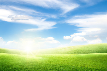 Beautiful landscape view of Green grass natural meadow field and little hill with white clouds and blue sky in summer seasonal.
