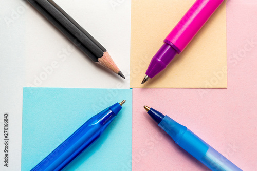 Colorful blank sheets of paper notes with blue and pink pens and pencil composition Back to school concept with stationery office supplies on a blue wooden background close-up top view