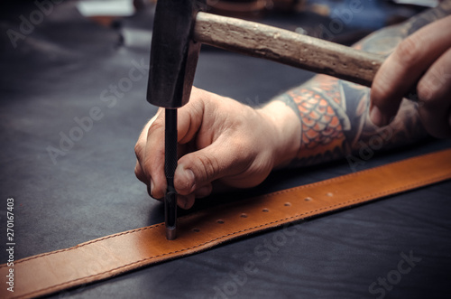 Foto Professional Leather Worker cuts out leather goods at his tanning shop