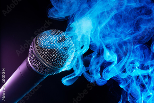 microphone and blue smoke swirls on black background.