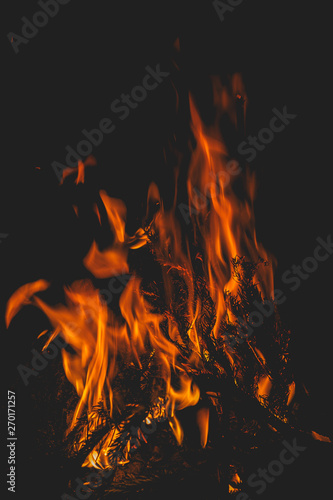 dark background bonfire from branches in the fireplace . flame and sparks.
