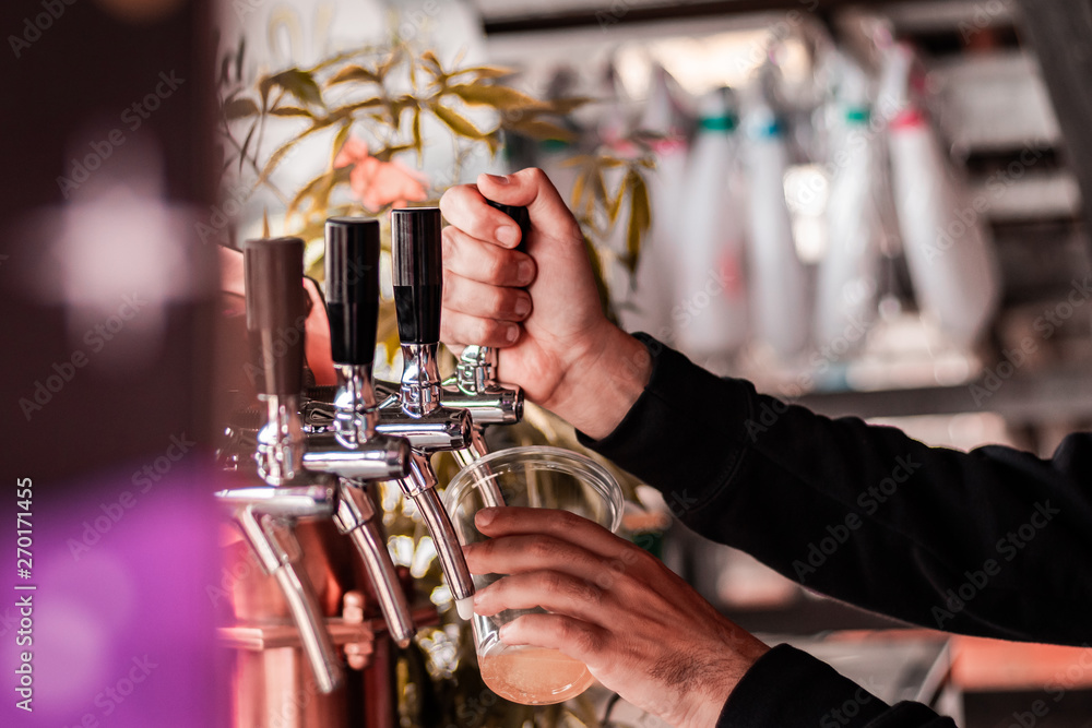 Obraz premium Artisan beer company serving free drinks during music festival. Macro shot of hands and levers. 