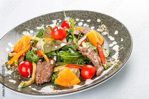 Warm salad with vegetables, arugula and veal