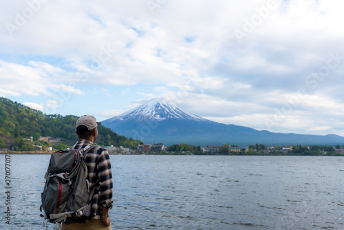 Young Boy Backpackers traveling Beautiful Fuji Mountain,  Men Backpacking Fujisan volcano at Kawaguchiko lake, Japan.