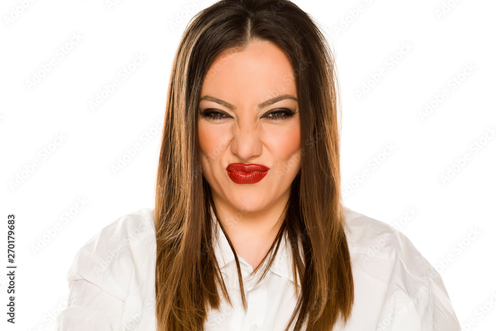 Portrait of beautiful woman with sour grimace on white background Portrait of beautiful woman with sour grimace on white background