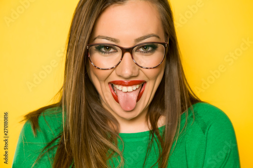 Portrait of beautiful funny woman and long hair on yellow background