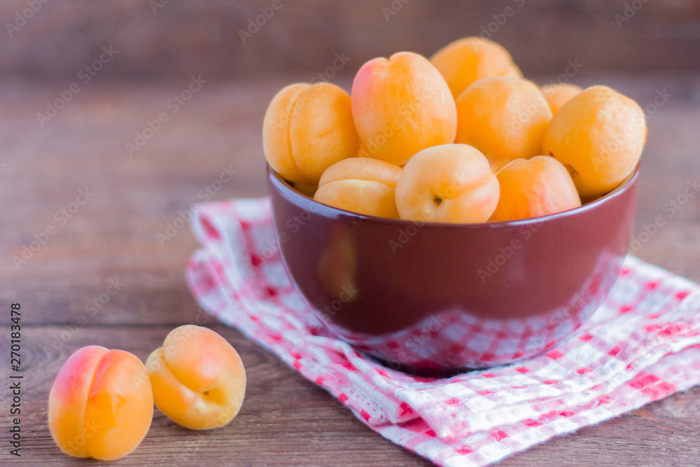 ripe fresh apricots in a bowl on a wooden table ripe fresh apricots in a bowl on a wooden table