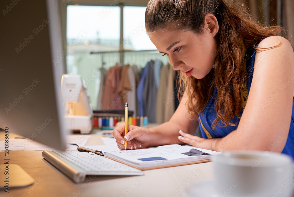 Fashion woman designer working with sketch in notebook drawing for new collection in office studio Fashion woman designer working with sketch in notebook drawing for new collection in office studio