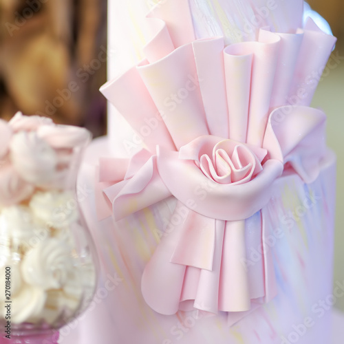 Delicious pink wedding or birthday cake decorated with bow