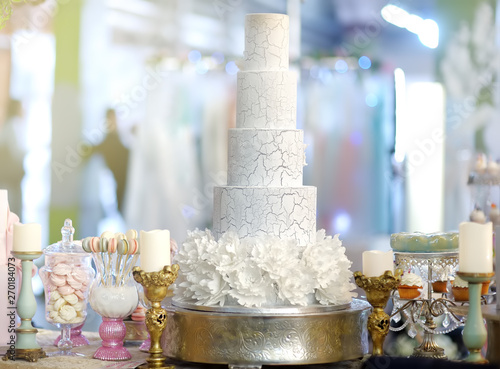 Traditional anniversary/wedding multi-layer cake. Beautiful delicious sweet dessert decorated with flowers. Stylish sweet table.