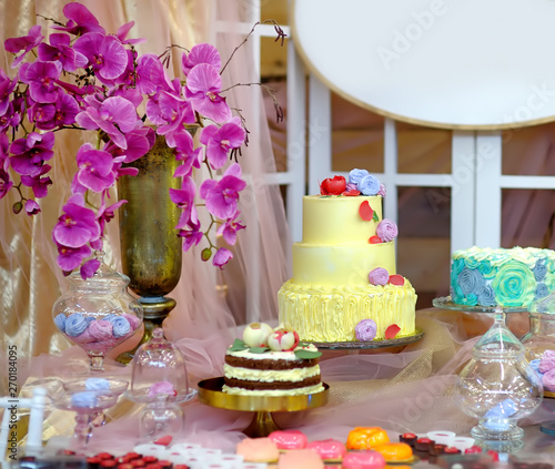 Traditional anniversary/wedding multi-layer cakes. Beautiful delicious sweet dessert decorated with flowers. Stylish sweet table.
