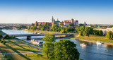 Poland. Krakow aerial panorama with historic royal Wawel castle and cathedral, Vistula river with a bridge, boats, on board restaurant. Promenades and parks along the riversides. Sunset light