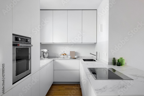 interiors shots of a modern white lacquered kitchen with wooden floor