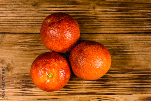 Three sicilian oranges on a wooden table. Top view