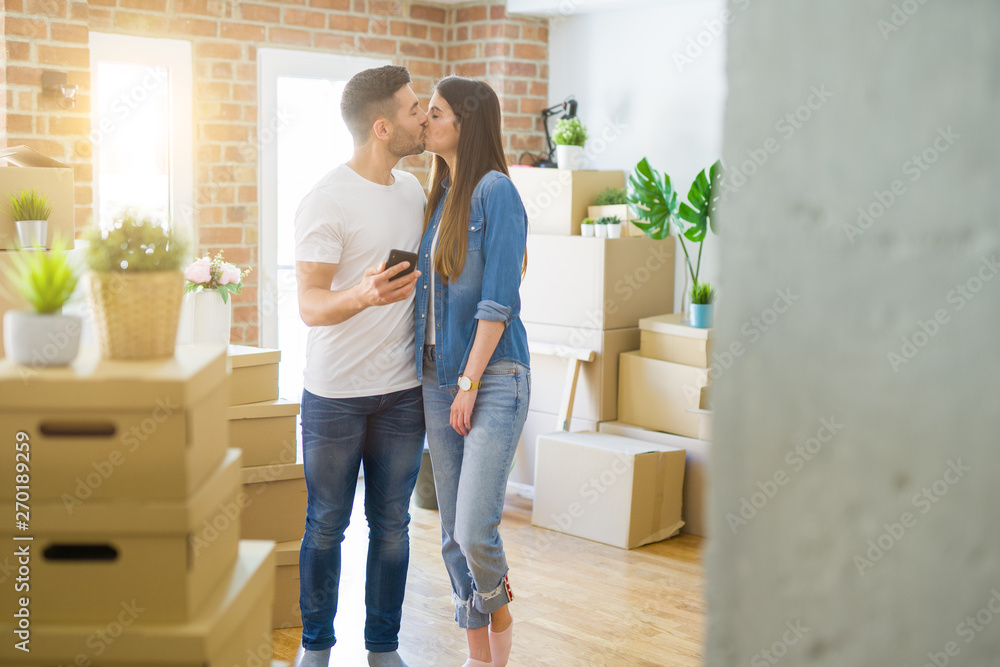 Young couple moving to a new house, using smartphone smiling very happy for new apartment Young couple moving to a new house, using smartphone smiling very happy for new apartment