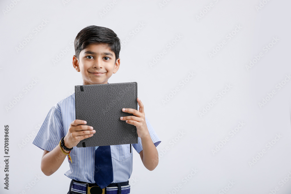 Cute little Indian/Asian school boy showing note book over white background Cute little Indian/Asian school boy showing note book over white background