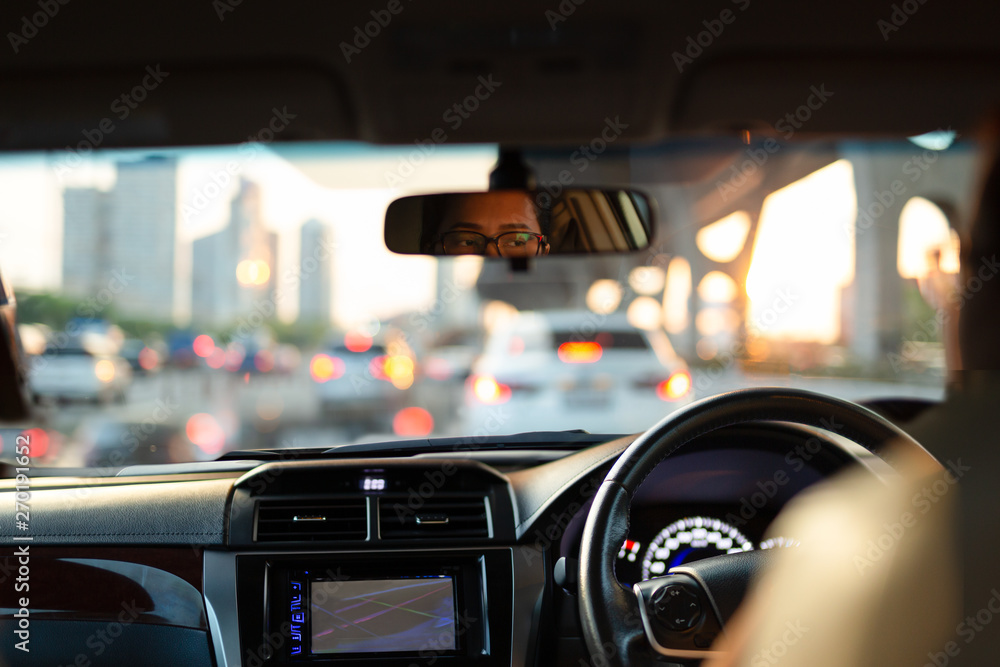 Woman looking bored in her car while stuck in traffic jam.
