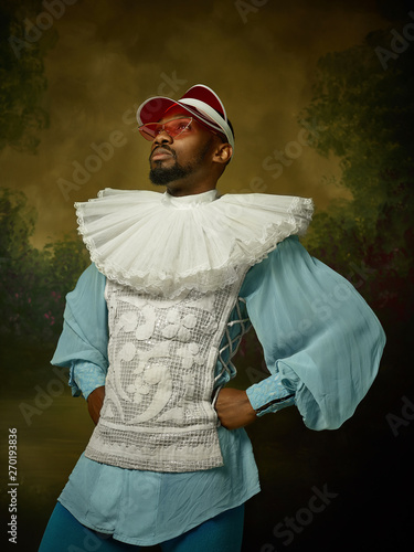 Bild auf Leinwand Young man as a medieval grandee or nobleman on dark studio background