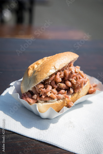 Nordseekrabben Brötchen als Fischbrötchen auf Fischmarkt Holztisch als schneller regionaler Imbiss